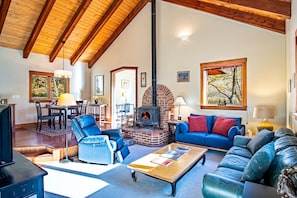 A spacious living room with a fireplace, comfortable seating, and a dining area. - Creekside on Quigley - 3BD Private Home on trails + Hot Tub (Hailey)