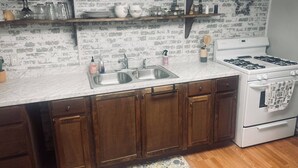 A kitchen with wooden cabinets, a white stove, and a marble countertop.