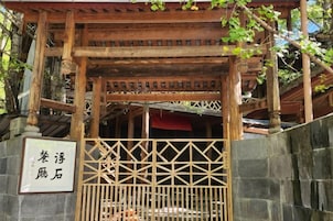 Un torii japonés tradicional con estructura de madera y base de piedra.