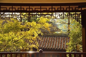 A traditional building with a tiled roof and a wooden fence with geometric patterns. - First Sight Boutique Cottage (Tengchong)