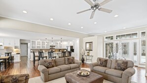 A spacious living room with a large brown sectional sofa, a brown leather ottoman, and a dining area with a kitchen in the background. - Private luxury in beautiful Yakima wine and hop country (Naches)