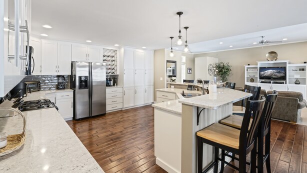 A modern kitchen with white cabinetry, stainless steel appliances, and a central island with bar stools. - Private luxury in beautiful Yakima wine and hop country (Naches)