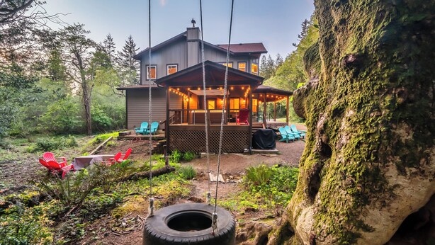 Une maison avec une véranda, un espace salon ext érieur et une balançoire.