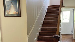 A wooden staircase with white handrails, leading to a door with a window. - The Whitehouse. (Green Cove Springs)