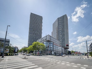 Um cruzamento urbano com edifícios modernos, faixas de pedestres e semáforos.