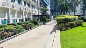 Un bâtiment moderne doté de nombreux balcons, d’une pelouse bien entretenue et d’un chemin clairement défini.