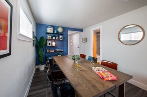 Ein Essbereich mit einem Holztisch, Stühlen, einem Globus auf einem Regal und einem gerahmten Bild an der Wand.