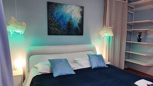 A bedroom with a bed, pillows, a painting, a nightstand, and a shelf. - 2 Bedroom Apartment Sleeps 4 -Free Parking -Garden (Zadar)