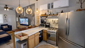 A modern kitchen with a central island, stainless steel appliances, and pendant lighting. - Cabo Oasis Escape - 1 bedroom Apartment (Cabo San Lucas)