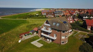 Eine Vogelperspektive eines Wohngebiets mit Häusern, einem Strand und einem wolkenlosen Himmel.