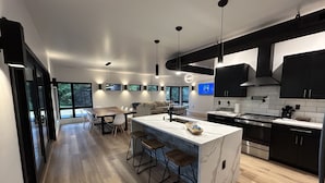 Une cuisine moderne dotée d’un îlot central, de tabourets de bar et d’un coin repas avec un canapé.