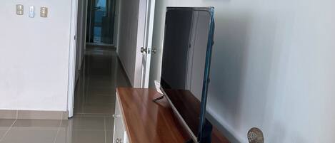 A hallway with a wooden counter, a flat-screen TV, and a decorative rock stack.