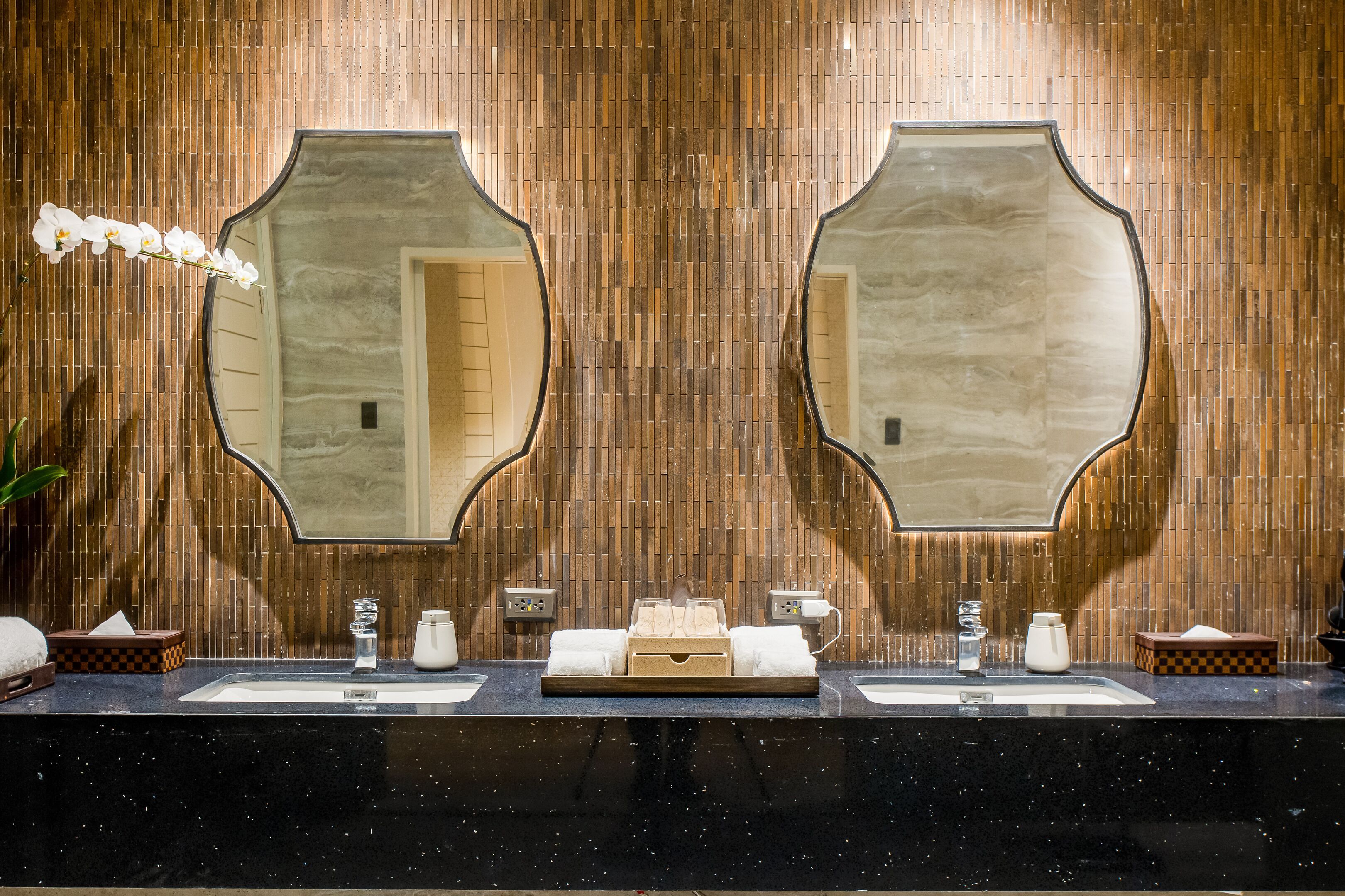 A bathroom with two sinks, a mirror, and a towel rack.