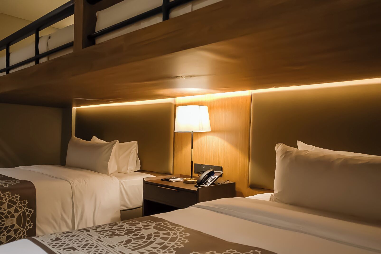 Ein Hotelzimmer mit zwei Betten, einem Nachttisch mit Lampe und einem Telefon.