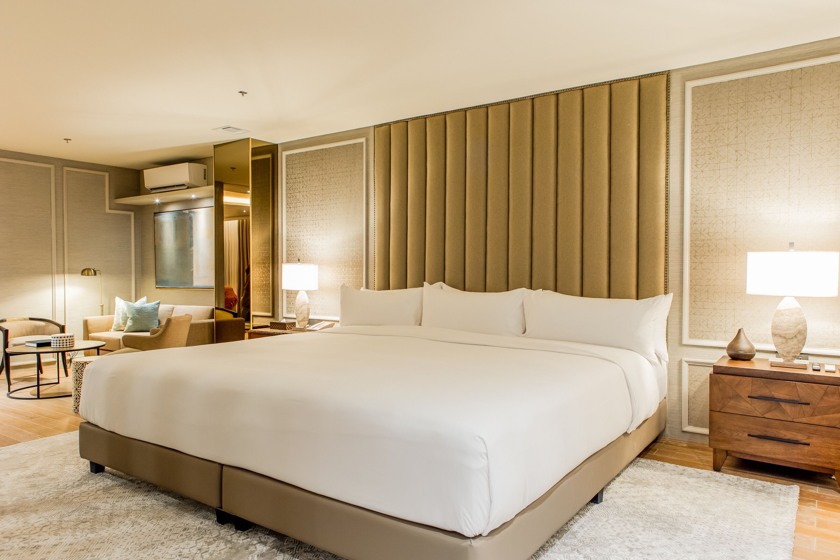 A spacious bedroom with a large bed, a bedside table with a lamp, and a nightstand.