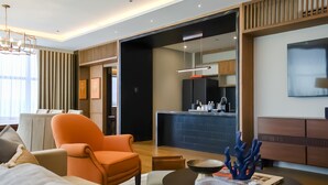 A modern hotel room with a living area, a dining table, and a kitchen area. - Brittany Hotel Villar City (Bacoor City)