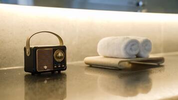Una radio su un ripiano del bagno, con asciugamani e un rasoio.