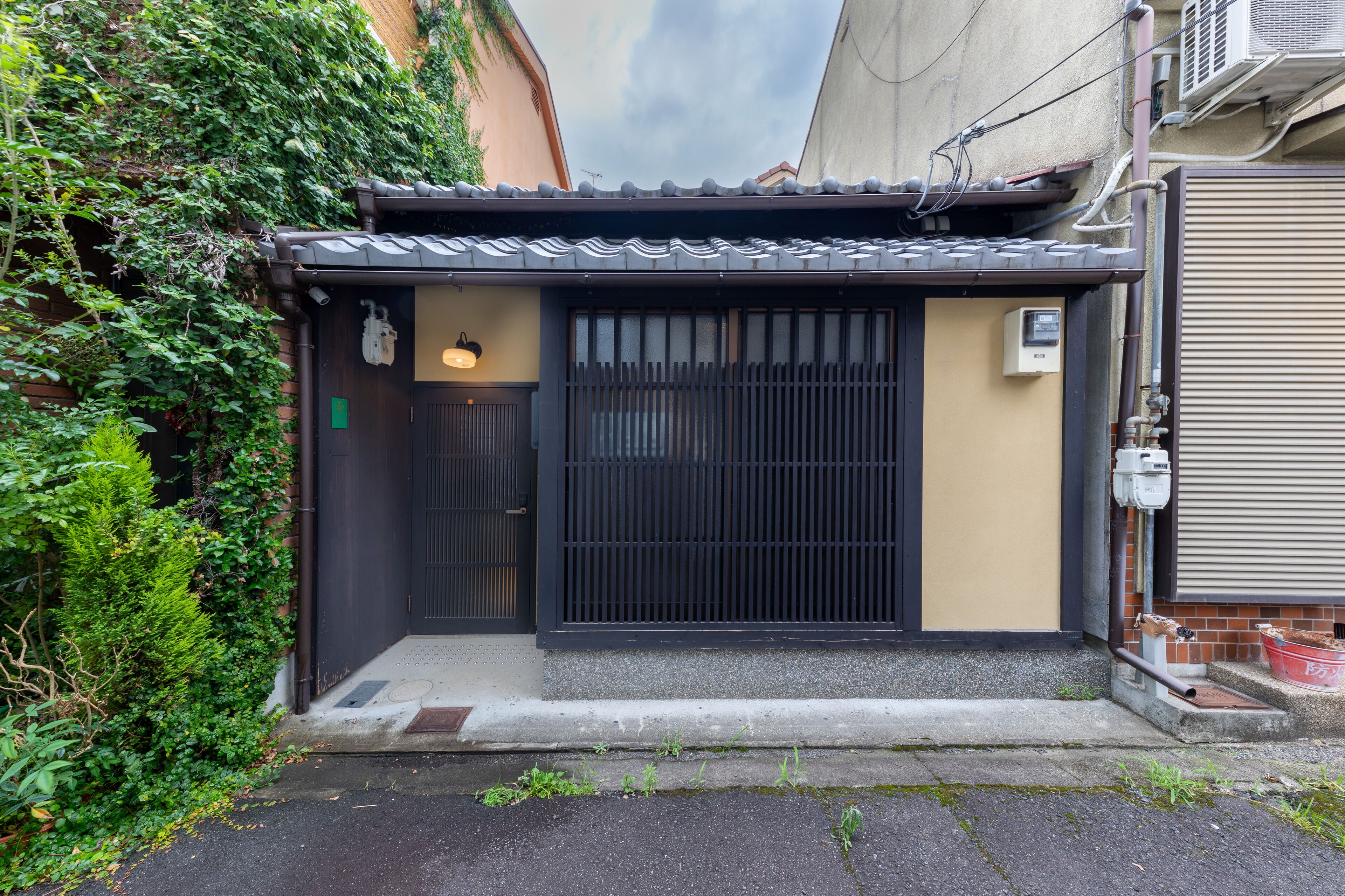 A traditional Japanese house with a sliding door, a small porch, and a tiled roof.