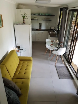Enjoy a compact living space with a modern kitchenette, dining area, and comfortable seating.