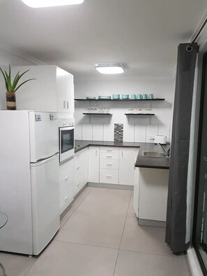 Enjoy cooking in this well-equipped kitchen with a sink, refrigerator, oven, and microwave.