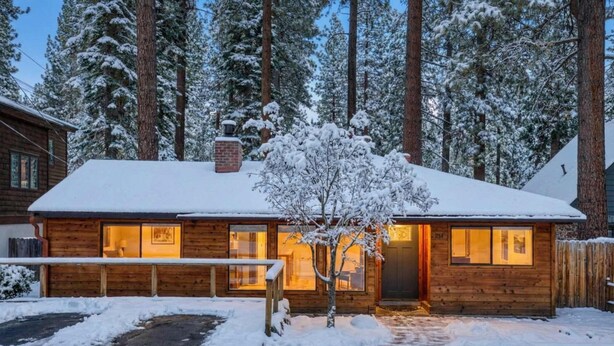 A wooden cabin with a snow-covered roof, surrounded by tall pine trees. - Agate Bay 3BDR, Walking Distance to the Beach! (Tahoe Vista)