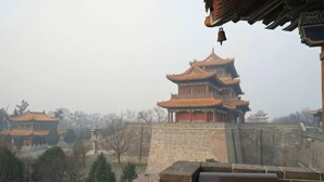 A traditional Chinese building with multiple tiers and a bell.