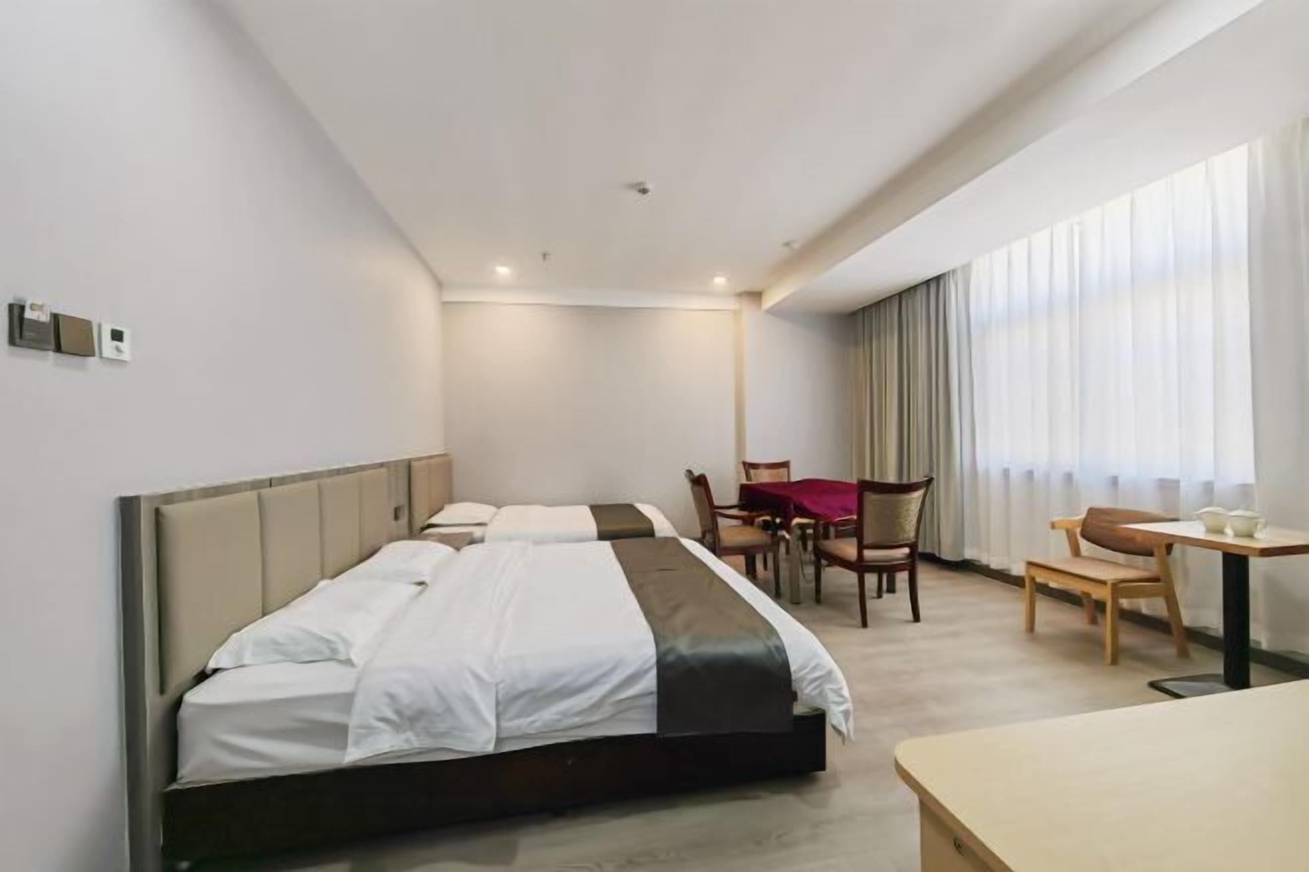 Quarto de hotel com uma cama, uma mesa e uma cadeira.