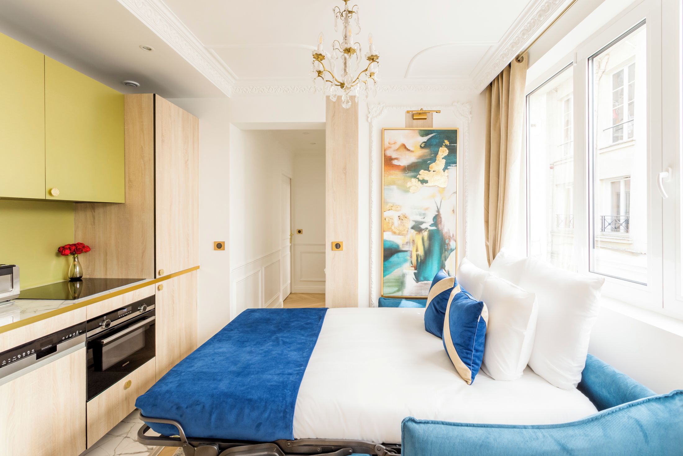 Ein Hotelzimmer mit Bett, Schreibtisch und Blick auf die Stadt.