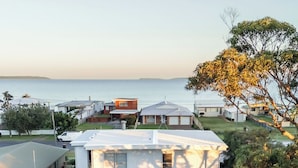 Une maison à deux étages dotée d’un patio couvert et offrant une vue sur la mer.