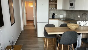 A modern kitchen with a microwave, toaster, and wine glasses on the shelf. - Vacation Apartment 'Bluebell L6' with Wi-Fi and Air Conditioning (Armeñime)
