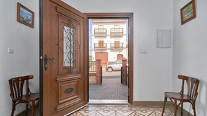 An open wooden door leading to a tiled entrance area with two wooden chairs. - Holiday Home 'Rafalita' with Sea View, Wi-Fi and Air Conditioning (Torrox)