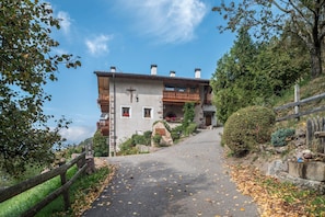 Un bâtiment à deux étages doté d’un balcon, d’une façade en pierre et d’une allée pavée.