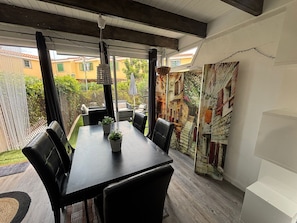 Un comedor interior con una mesa, sillas y una lámpara colgante.