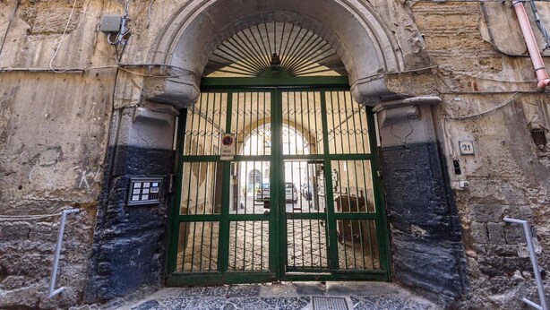 An arched entrance with a green gate, a stone wall, and a number '21' sign. - Vico Sedil Capuano 21 - Appartamento 1 (Naples)