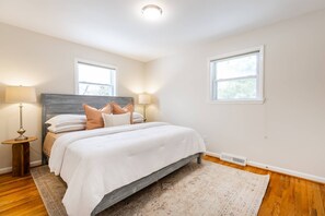 A bedroom with a bed, two bedside lamps, a window, and a radiator. - Game Days & Family Stays at Dog-Friendly Home Near Navy Stadium w Private Fenced-In Yard (Annapolis)