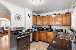 Kitchen features a stainless steel stove, sink, and ample countertop space.