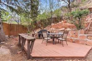 Enjoy al fresco dining on the deck surrounded by lush greenery.