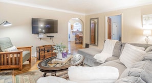 Relax in the cozy living room with a comfortable sofa, armchair, and flat-screen TV.