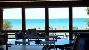 A dining area with a view of the ocean through large windows.