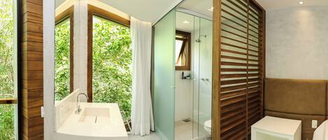 A modern bathroom with a glass-enclosed shower, a white sink, and a wooden vanity.