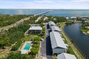 An aerial view of a resort with a swimming pool, a dock, and a marina.