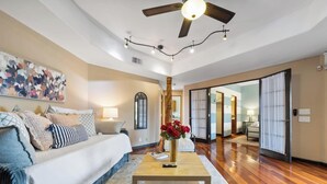 A spacious living room with a sofa, coffee table, and a ceiling fan.