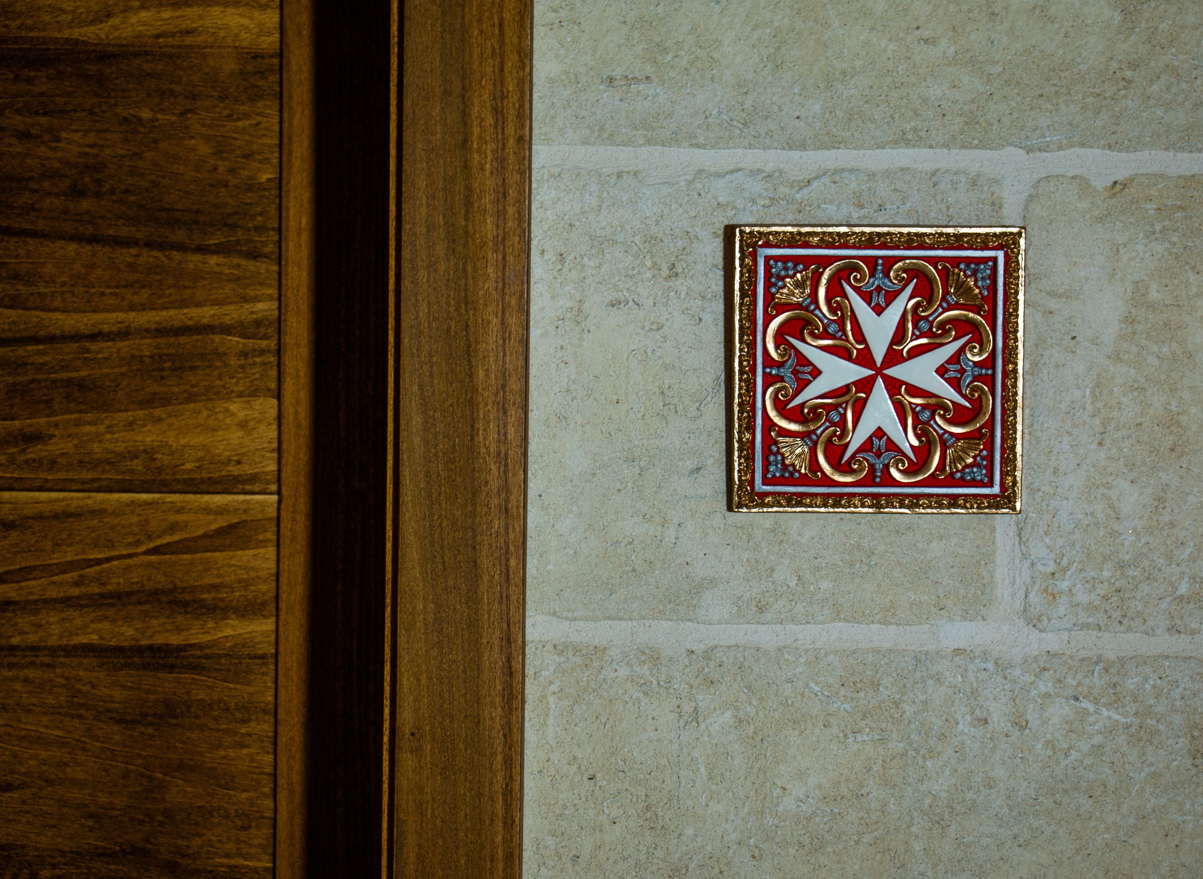 A wooden door and a decorative plaque on a stone wall.