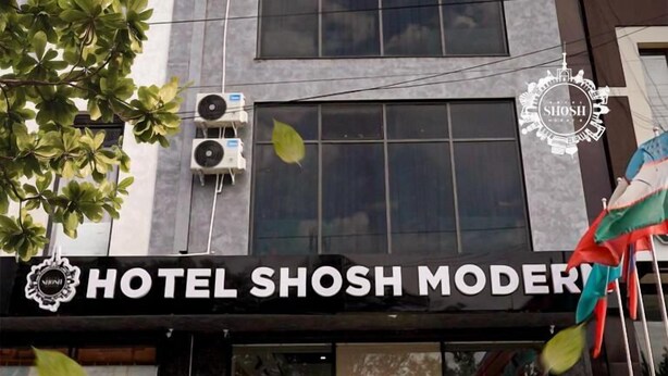 A hotel entrance with a modern facade, air conditioning units, and a sign reading "HOTEL SHOSH MODER". - Modern Hotel (Tashkent)