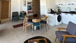 Een moderne woonkamer met een eetgedeelte, een keuken en een wasruimte.