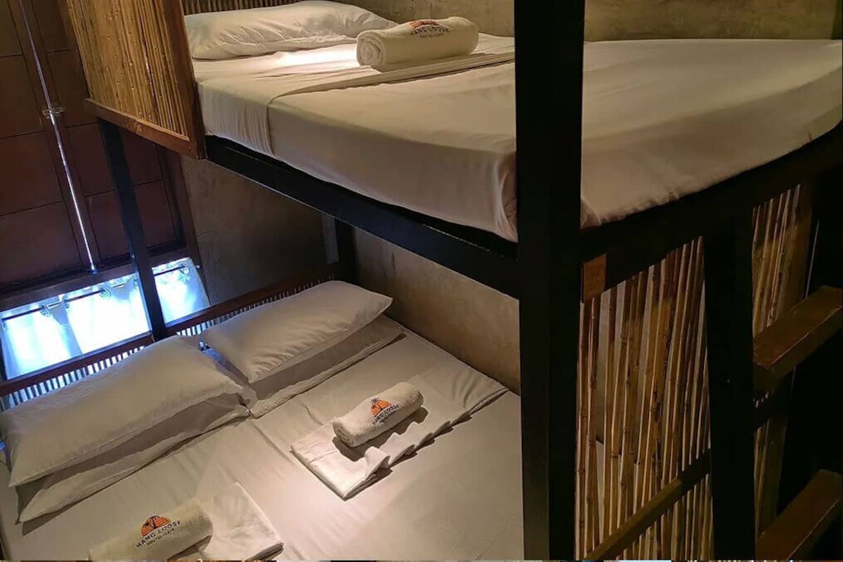 Habitación con literas, ropa de cama y toallas blancas.