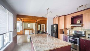 A spacious kitchen with a large island, wooden cabinets, and modern appliances.