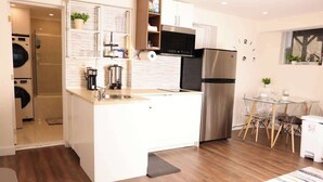 A compact kitchen with a built-in oven, microwave, and refrigerator. - Modern Basement Studio w/ Kitchen, Free Parking (Montréal)