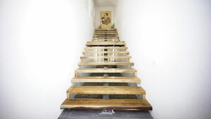 A wooden staircase with a minimalist design, leading to a room with a framed picture on the wall. - HOMU Villa Pua (Pua)