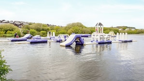 An outdoor water park with inflatable slides and play structures. - Sunbow at Retallack Resort (St. Columb Major)